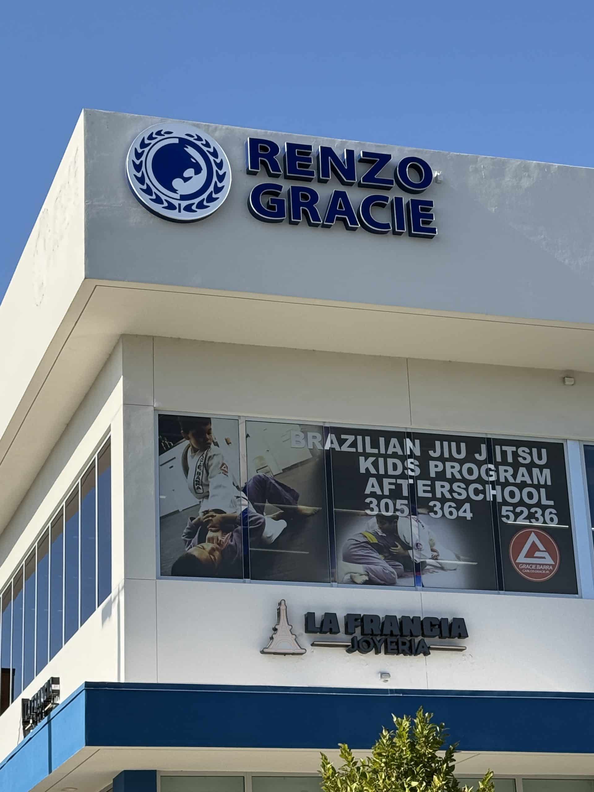 Exterior view of Renzo Gracie Jiu Jitsu academy in Miami, featuring branded building signage, kids program banner.